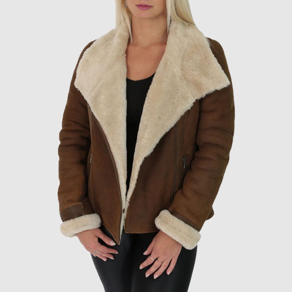 A woman wearing a brown leather aviator jacket with shearling cuffs and a collar, paired with black pants.