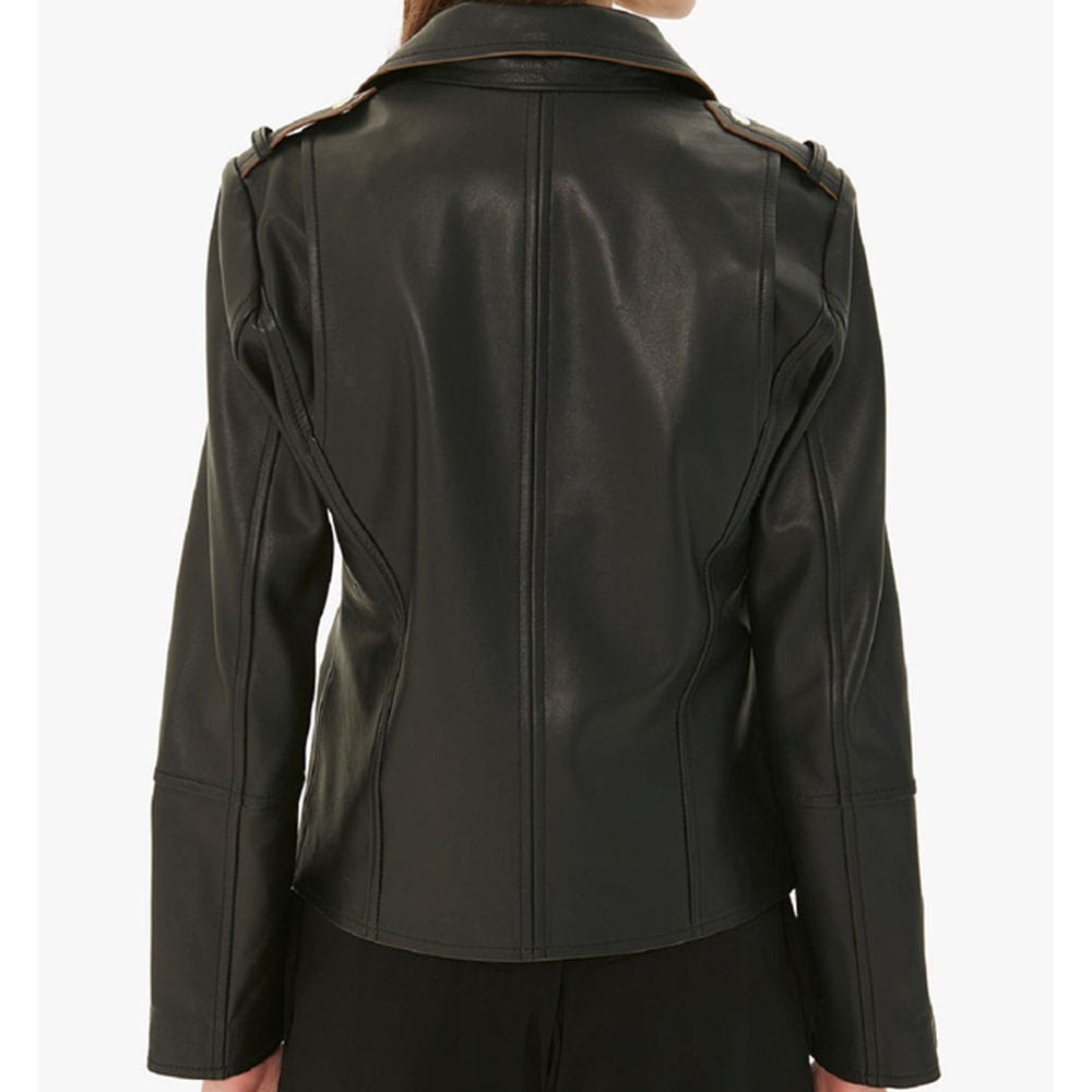 A woman wearing a black leather biker jacket with a standing collar, zipper cuffs, and a front zipper fastening, paired with dark pants.